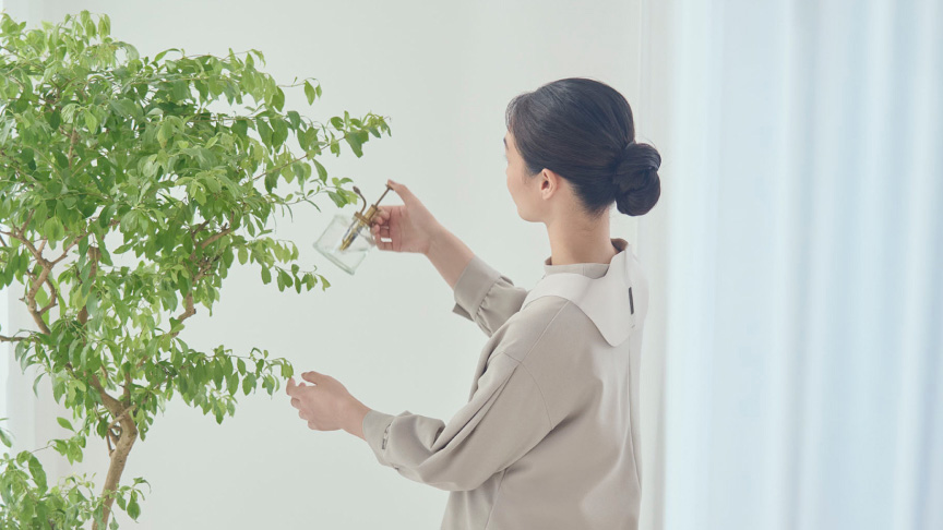 写真:コリコランワイドを使用しながら植物の手入れをしている女性の様子